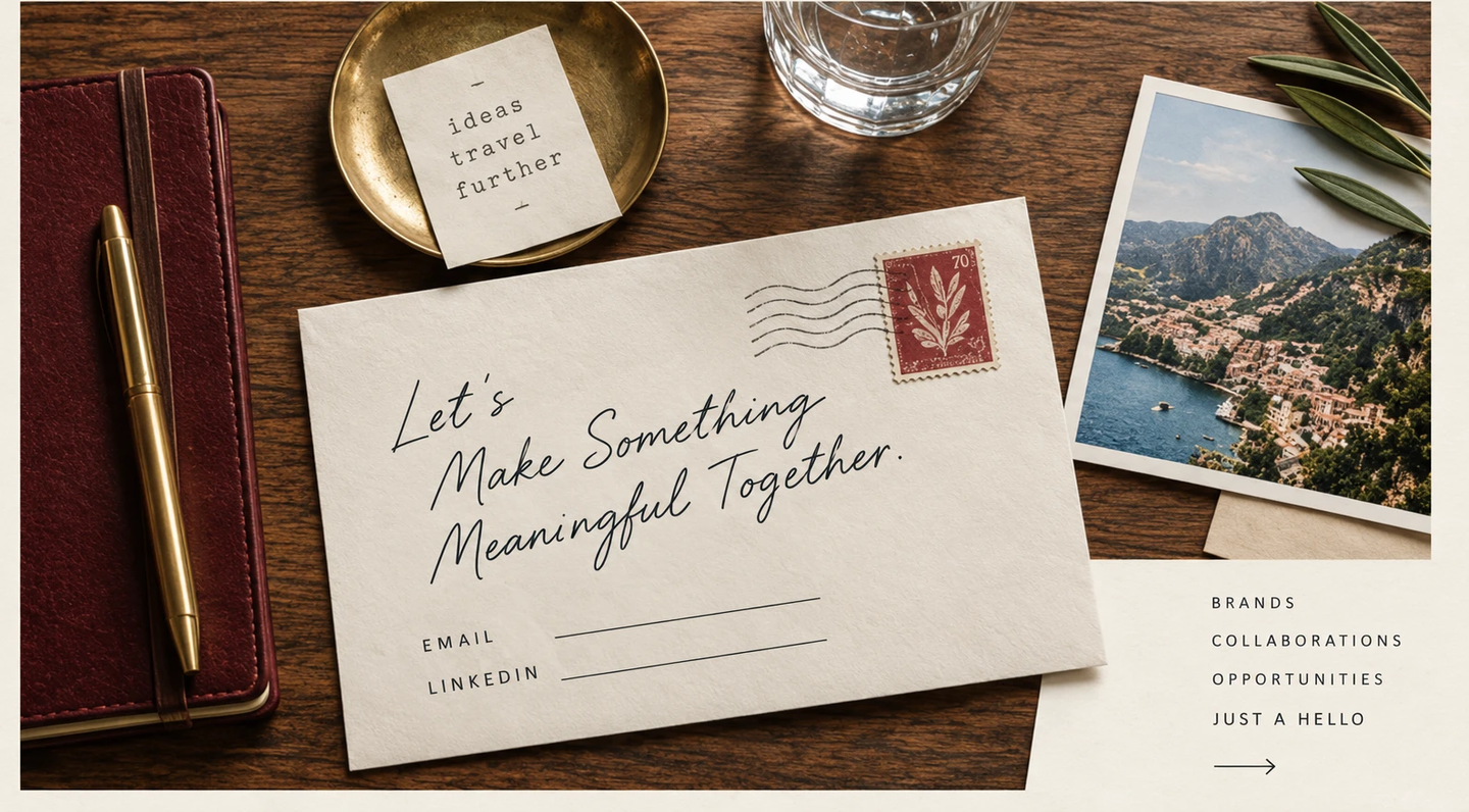 Overhead view of a walnut desk: a burgundy leather travel journal and brass pen at left, a small note reading 'ideas, travel, further' resting in a brass dish, a water glass, a cream envelope reading 'Let's Make Something Meaningful Together' addressed with an oxblood postage stamp and postmark waves, and a bordered photograph of a coastal village with an olive branch at the upper right. To the lower right, a cream panel lists Brands, Collaborations, Opportunities, and Just a Hello.